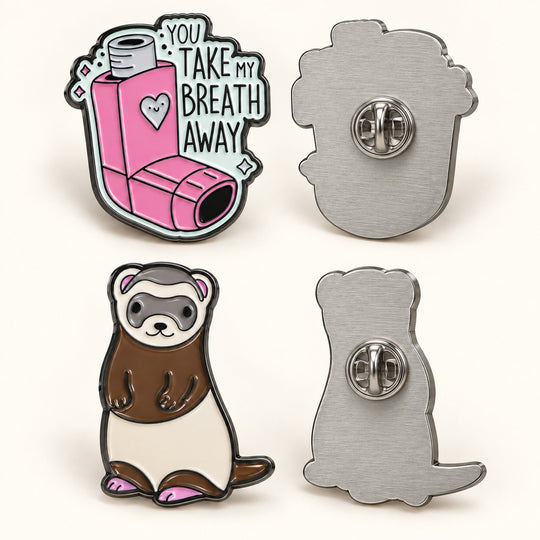 Vorder- und Rückseite eines rosa Inhalator-Pins und eines Frettchen-Pins mit Schmetterlingsverschluss