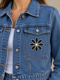 Zwarte bloem met zilveren rand strass patch op de borstzak van een spijkerjasje