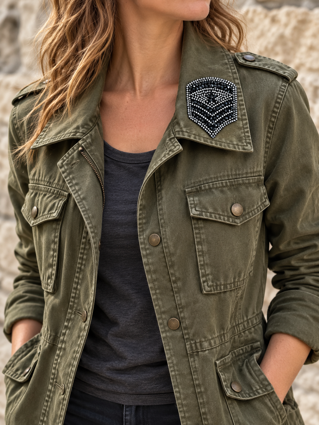 Zwart met zilverkleurig strass embleem op de kraag van een groen legerjasje