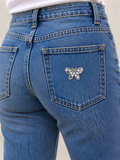 Zilveren vlinder strass patch op de achterzak van een spijkerbroek