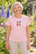 Sfeerbeeld: oudere dame in een bloementuin met Bloemenfeest als kleine rechtopstaande applicatie op haar shirt.